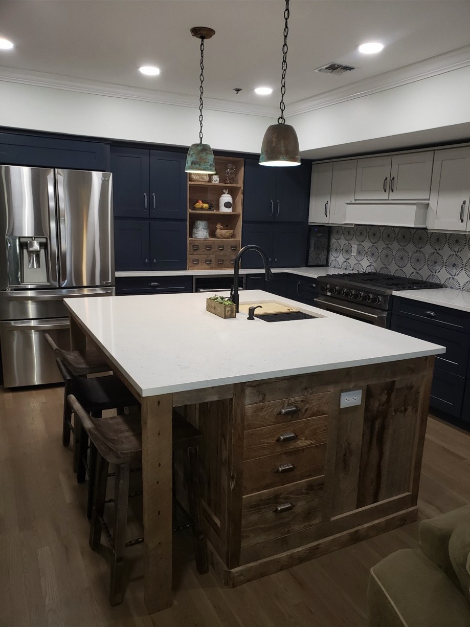 Navy kitchen cabinets and a rustic wood island