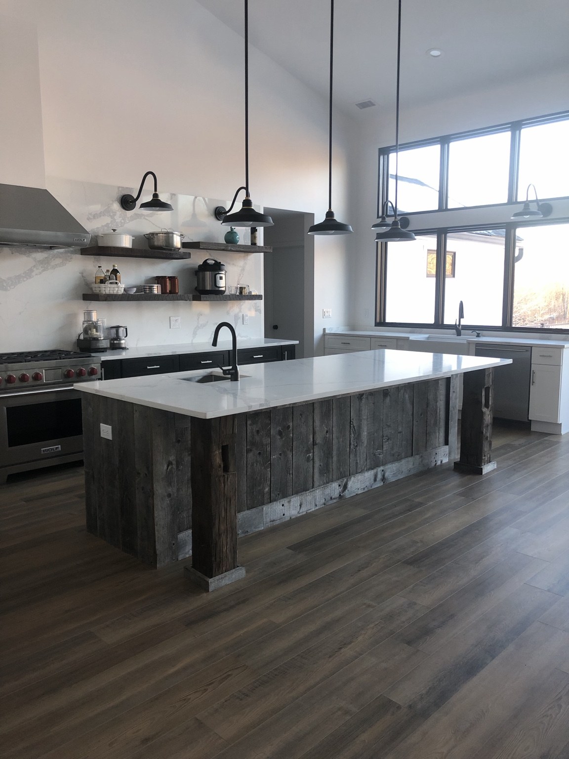Rustic wood island with a white countertop and full stone backsplash